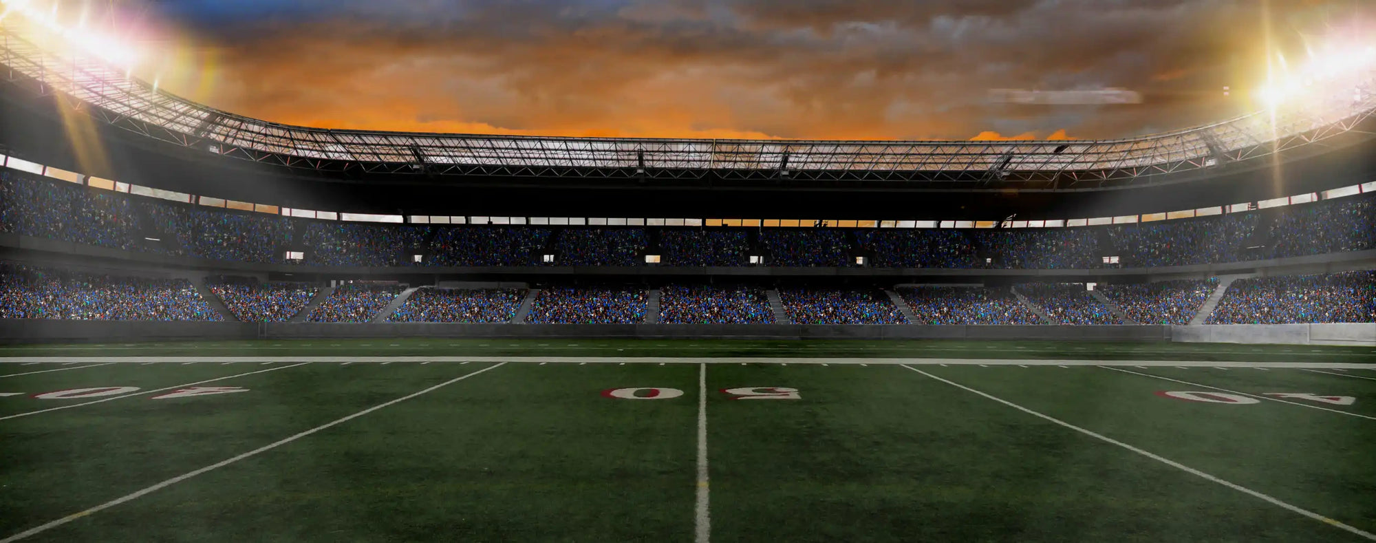 American football stadium with illuminated field, packed stands, and dramatic sunset sky before kickoff.