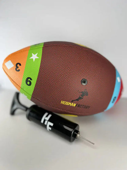 Colorful football with Heisman Trophy branding and a black pump on a white background